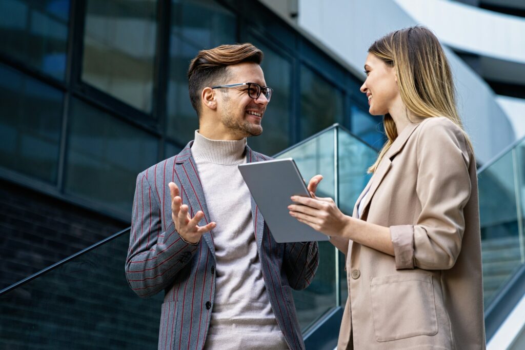 Two creative business people working on social media strategy using a digital tablet